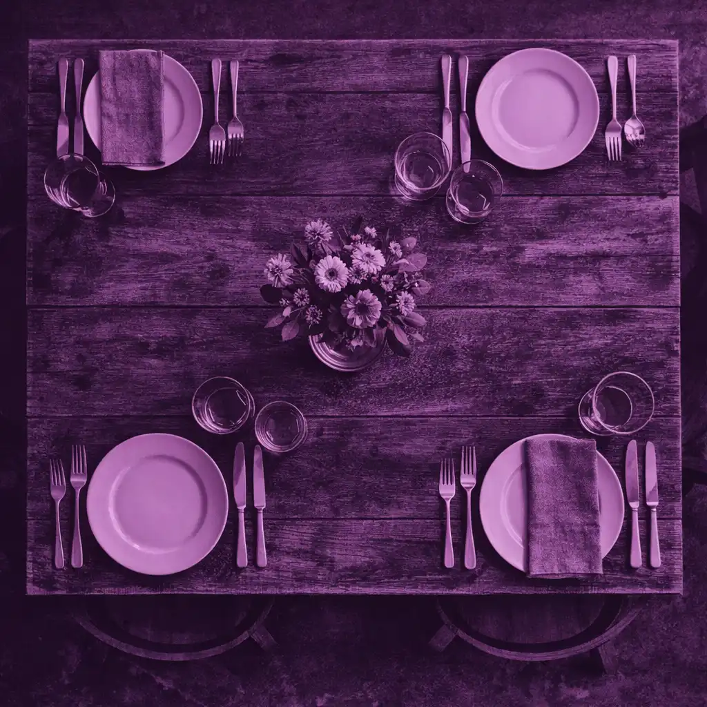 Top-down view of a set dining table with plates, napkins, and cutlery